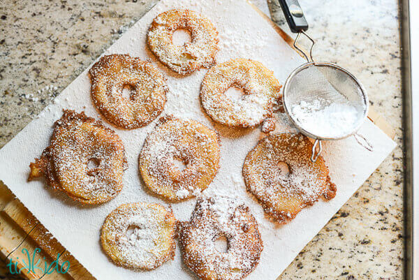 Apple fritter rings dusted with powdered sugar