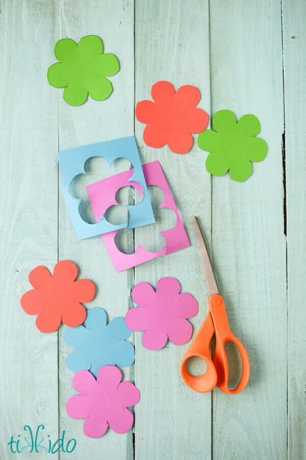 Flower shapes being cut out of colorful cardstock.
