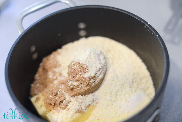 Brown sugar, white sugar, butter, and powdered milk being melted together to make Malted Pretzel Snack Mix.