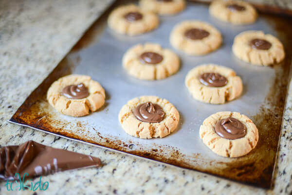 Peanut Butter Nutella Thumbprint Cookies on a baking sheet.