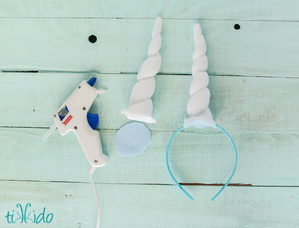 Photo showing how to attach felt unicorn horn to a headband with a low temperature glue gun.