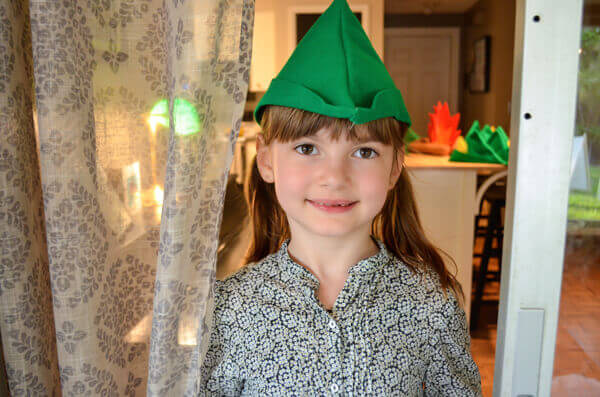 Little Girl wearing a green felt peter pan hat