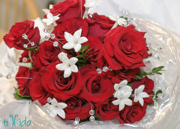 Wedding bouquet of red and white flowers, accented with clear crystal stems.