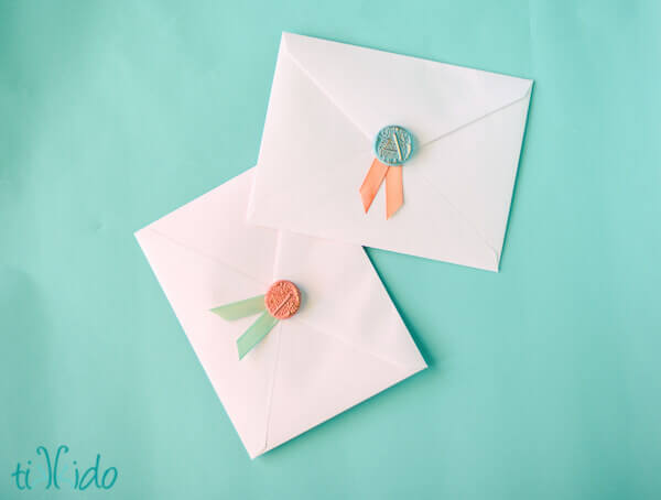 faux wax seals and ribbon decorating envelopes 