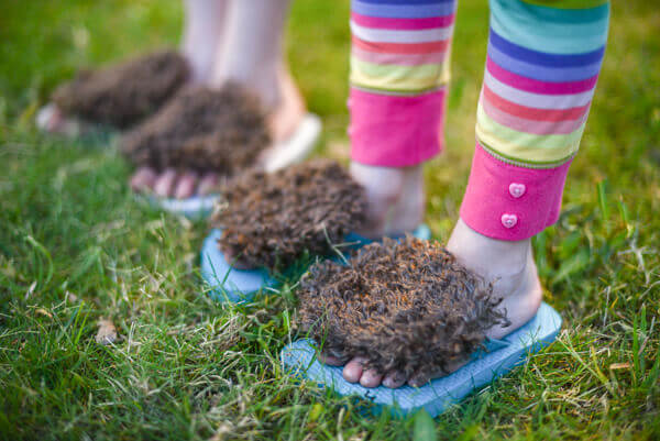 Closeup of two little girls' feet wearing DIY hobbit feet flip flops.