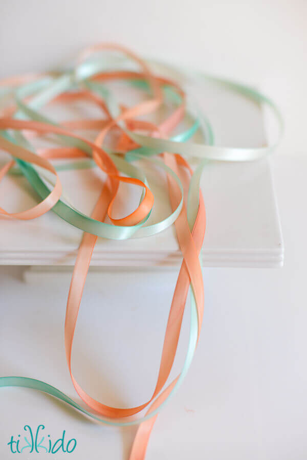 peach and teal hand-painted ribbons on a white surface.