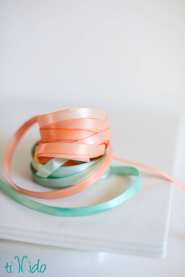 Painted ribbon painted with watercolor paints, coiled and stacked on a white background.
