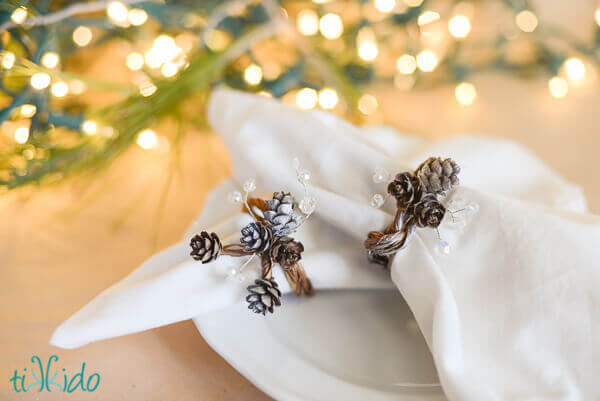 Pine Cone napkin ring with real pinecones and clear Swarovski crystals on a white napkin.