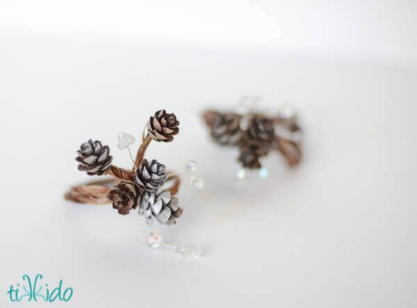 Pinecone napkin rings on a white surface.