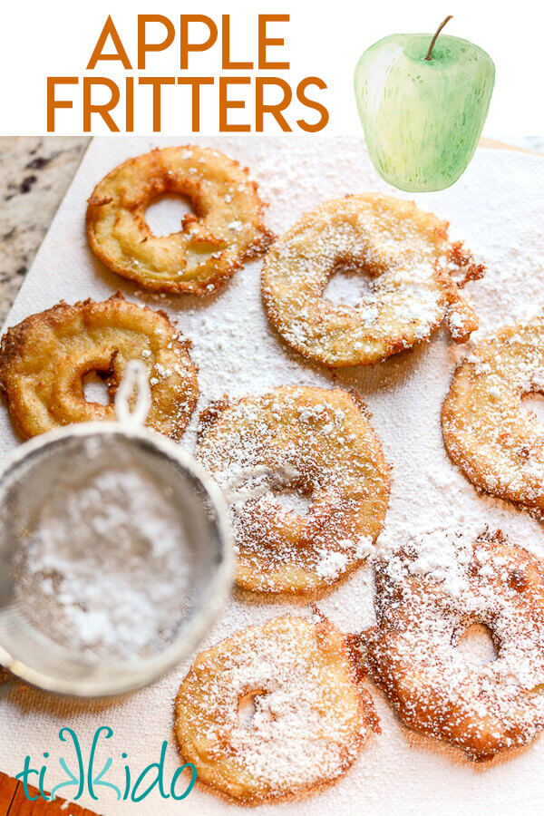 Apple fritter rings being dusted with powdered sugar.