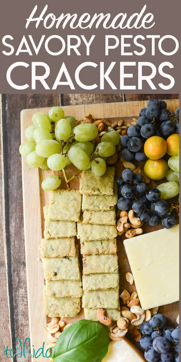 Pesto flavored savory shortbread crackers on a fruit and cheese board. 