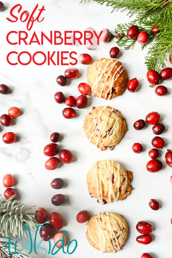 Cranberry cookies surrounded by fresh cranberries on a white marble background.