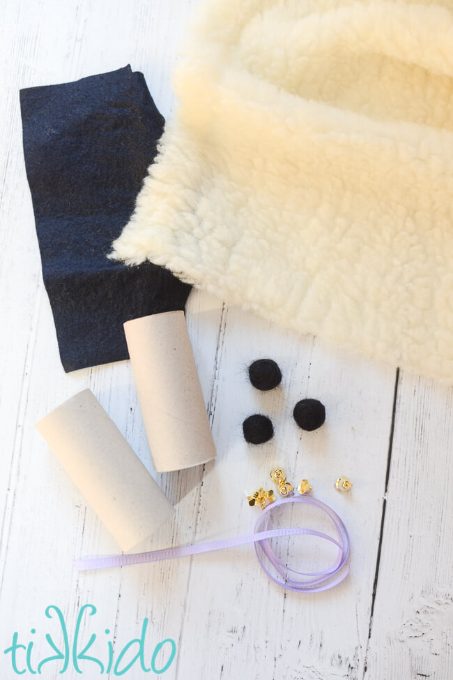 Materials for making Easter Sheep Napkin Rings on a white wooden surface.