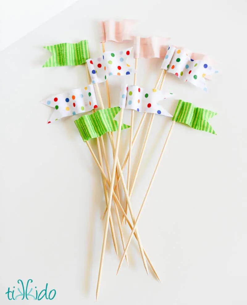 green striped and multicolor polka dot miniature flag cake toppers that look like they're waving in the wind.