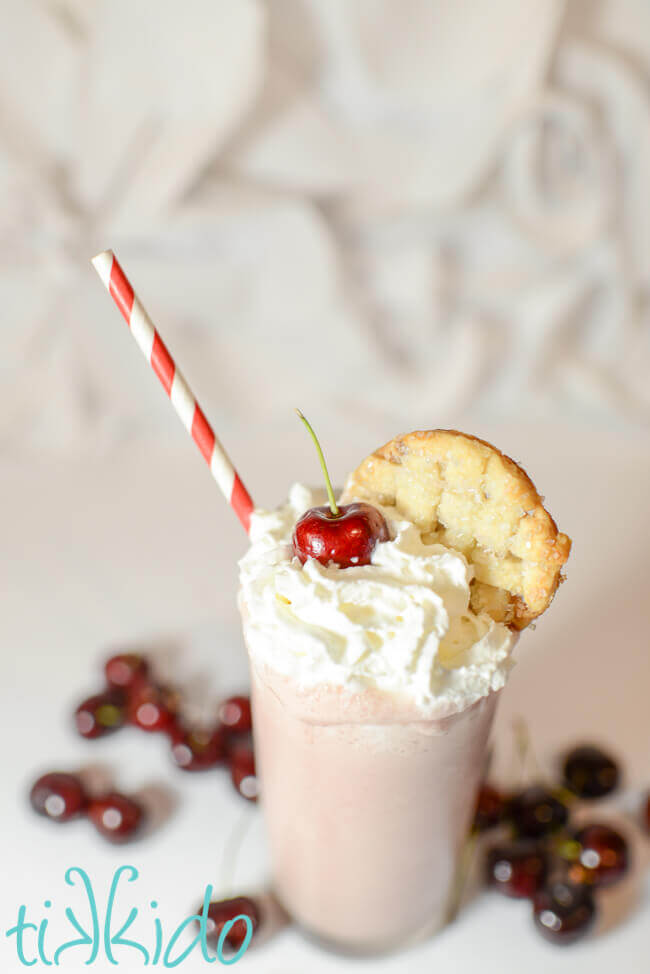 Cherry Pie milkshake topped with whipped cream, a fresh cherry, and a pie crust garnish.