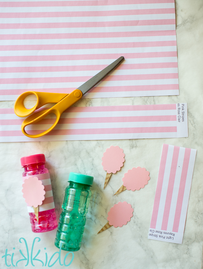 Scrapbook paper being used to decorate bubbles for favors for a cotton candy birthday party.
