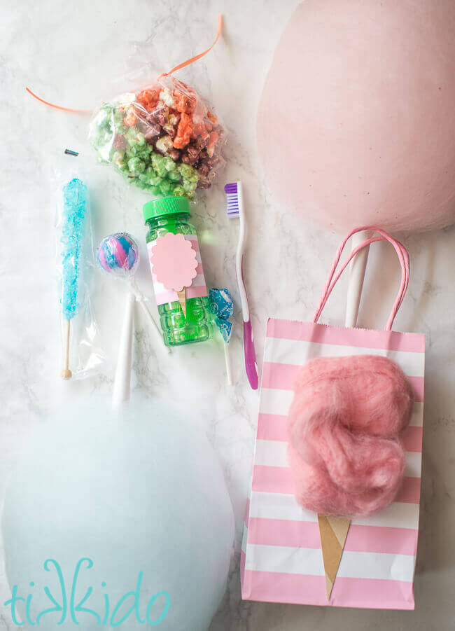 Cotton candy favors for a cotton candy birthday, including cotton candy popcorn, cotton candy lollipops, and a toothbrush.