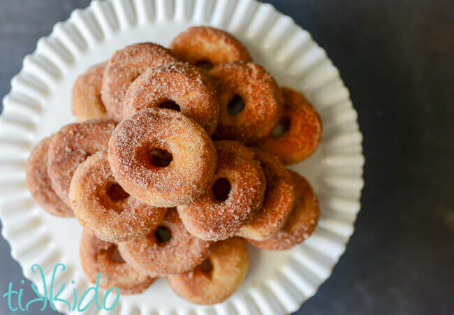 Cinnamon sugar cake donuts stacked on a white cake plate.  Handmade Cinnamon Sugar Cake Doughnut Recipe TIKKIDO doughnuts 14