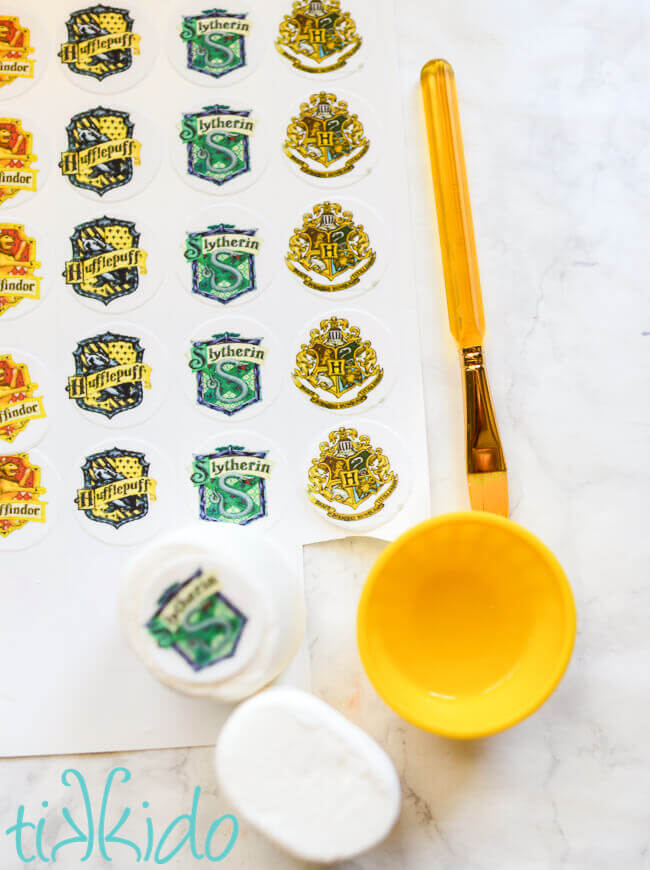 Harry Potter house crest edible images being put on marshmallows.