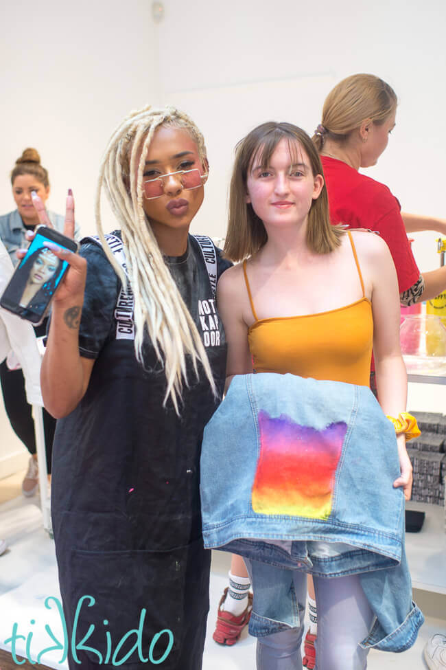 Artist Jade Laurice and a young woman holding a painted denim jacket.