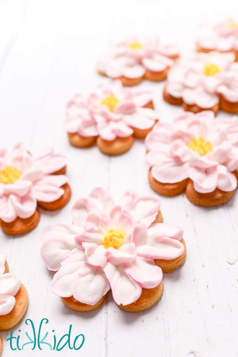 Sugar cookies decorated like a large flower, with pink and white royal icing.
