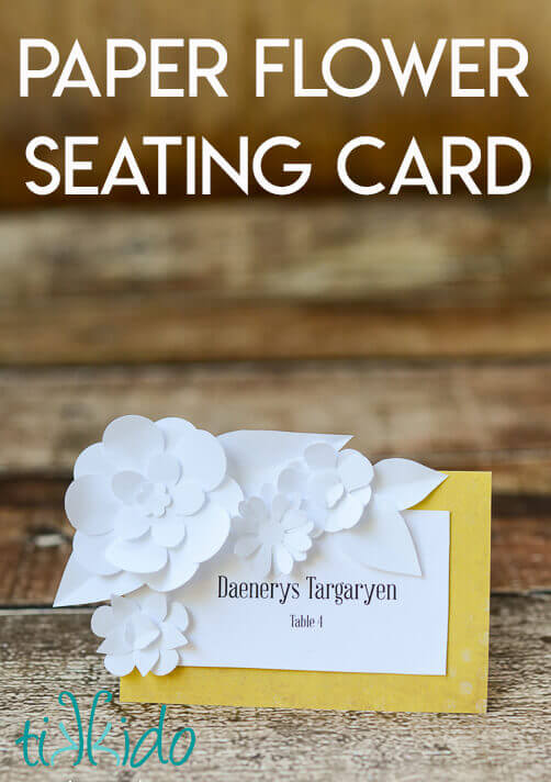 DIY Wedding seating card decorated with miniature paper flowers.