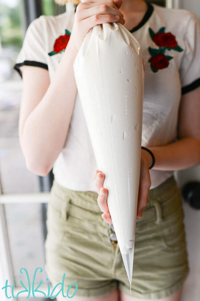Person holding large piping bag full of homemade marshmallow for filling for whoopie pies.