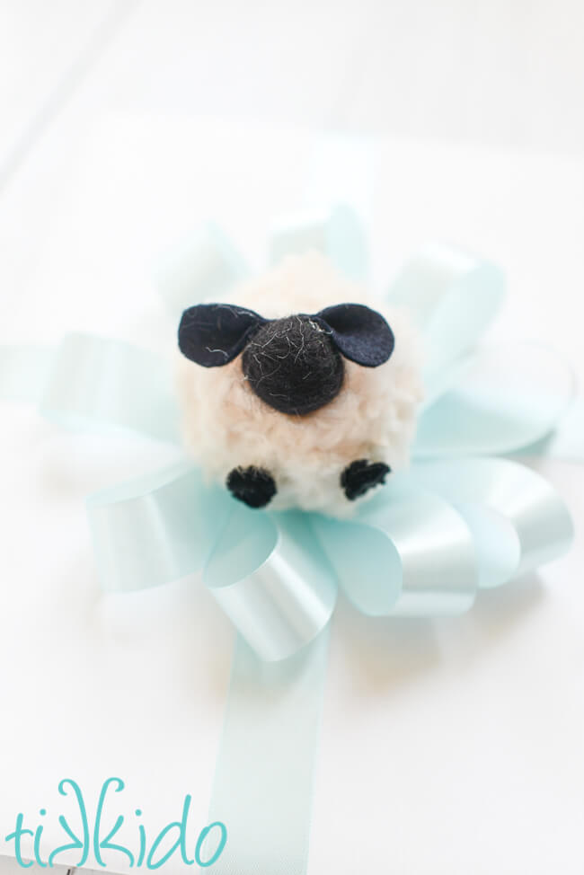 Pom Pom Sheep used as a gift topper for a baby shower gift.
