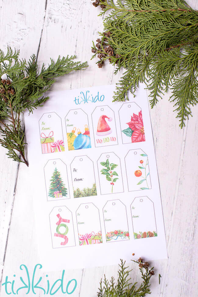 Sheet of Printable Christmas Gift Tags on a white wooden surface.