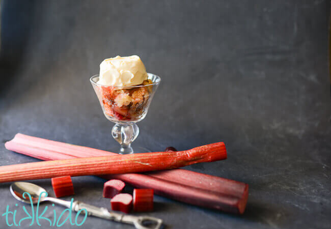 Rhubarb cobbler in a clear dish, topped with vanilla ice cream