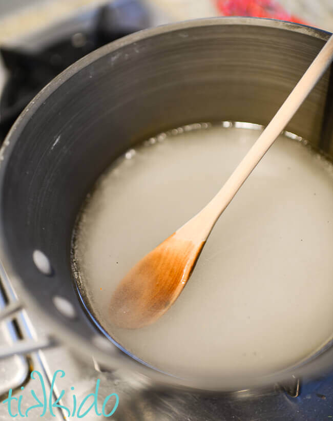 Simple syrup being made in a pot on the stove.