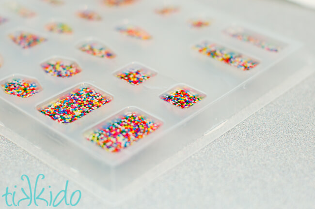 Resin cabochons filled with real sprinkles being made to make sprinkle resin jewelry
