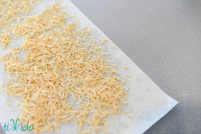Dehydrated, shredded cheese on a paper towel.