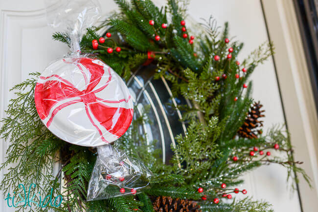 Easy, inexpensive, large scale peppermint decorations for Christmas made from paper plates decorating a wreath