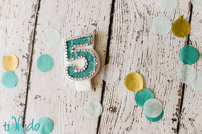 Number five birthday candle embellished with glitter and rhinestones to match a party theme.