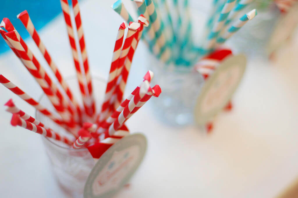 Homemade hot chocolate flavor add ins packaged in striped paper straws.