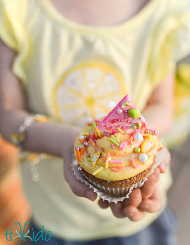 Homemade sprinkles on a cupcake being held by a little girl.