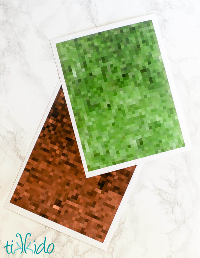 pixelated green and brown printable minecraft paper on a white marble background.