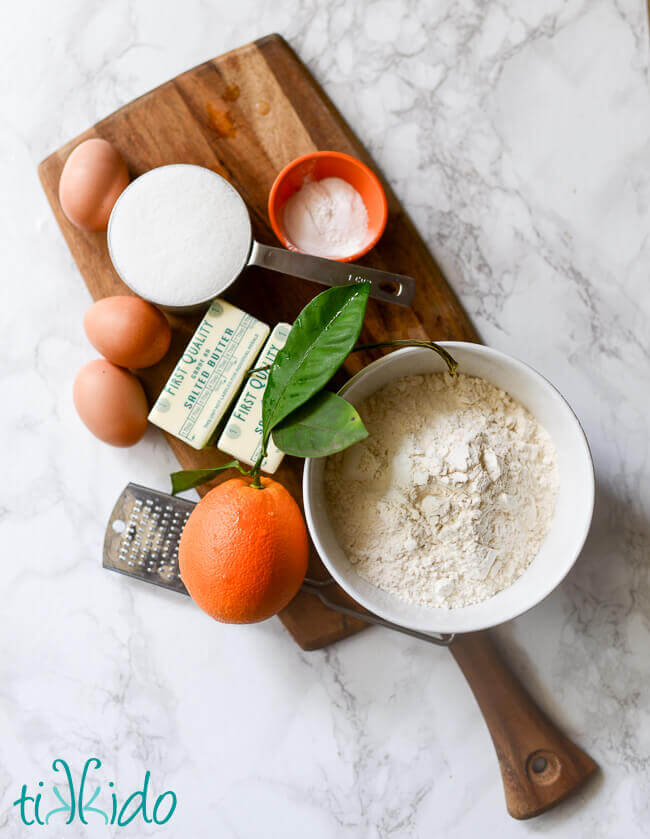 Ingredients for the BEST orange bundt cake on a wooden cutting board.