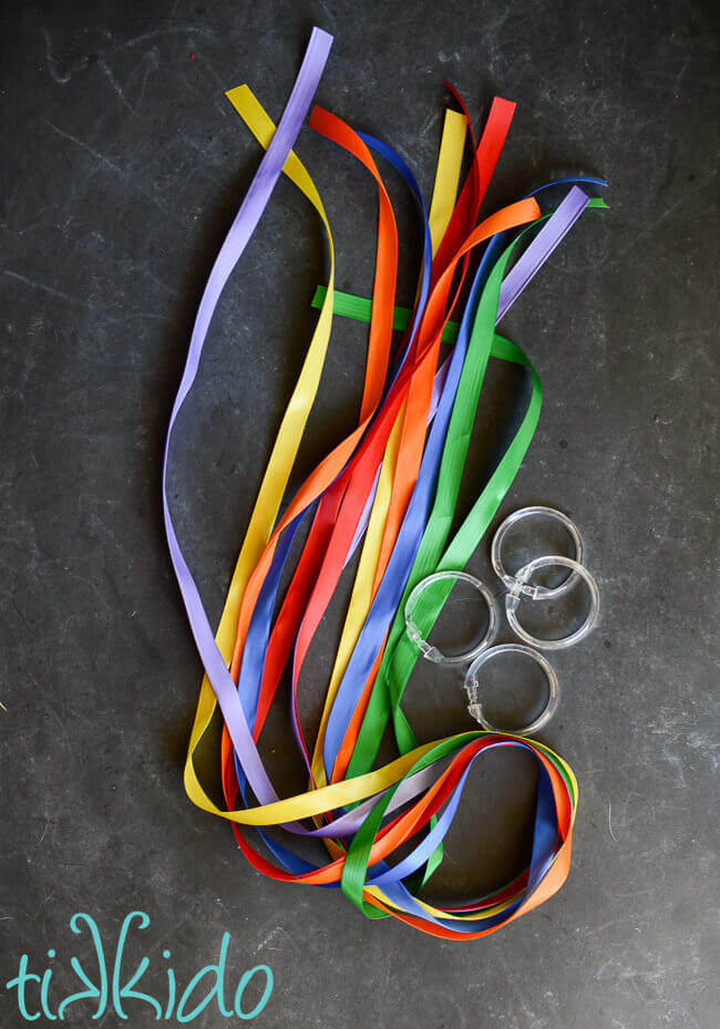Materials for making a Rainbow Ribbon Toy on a chalkboard background.
