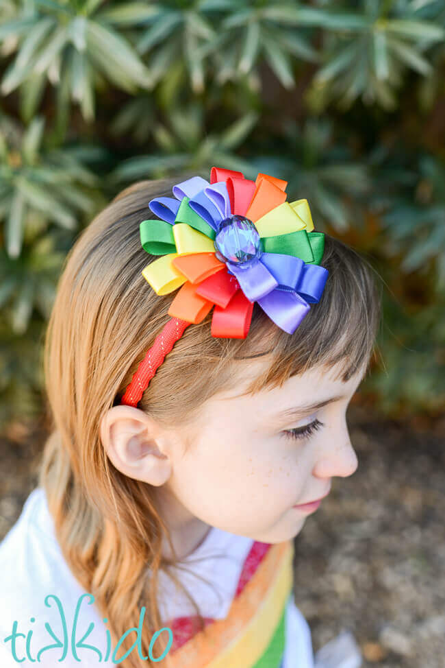 Little girl wearing a DIY Rainbow ribbon flower headband.