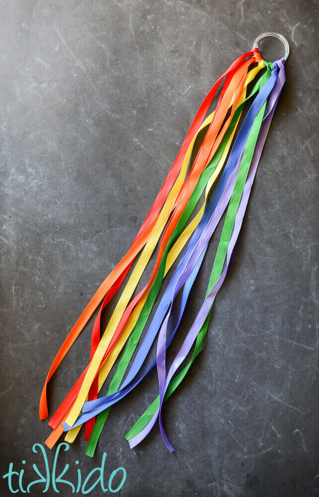 Easy DIY Rainbow Ribbon Toy on a chalkboard background.