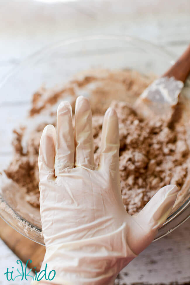 Hand wearing a plastic food service glove to make gingerbread salt dough ornament recipe.