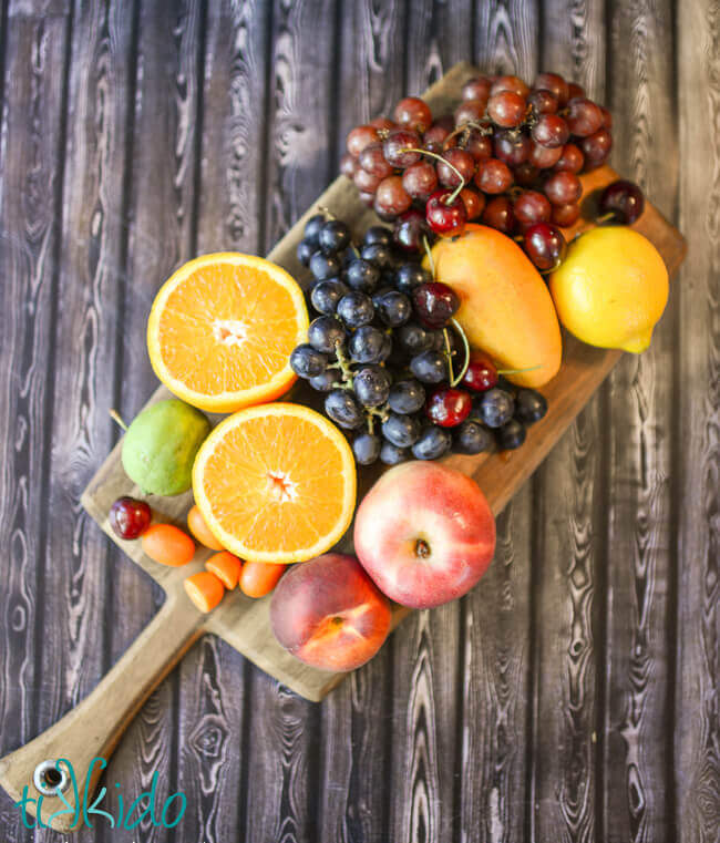 Fresh fruits on a wooden cutting board for the red sangria recipe.