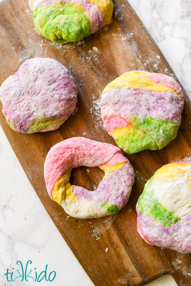 Unicorn bagel dough being shaped into bagel shapes.