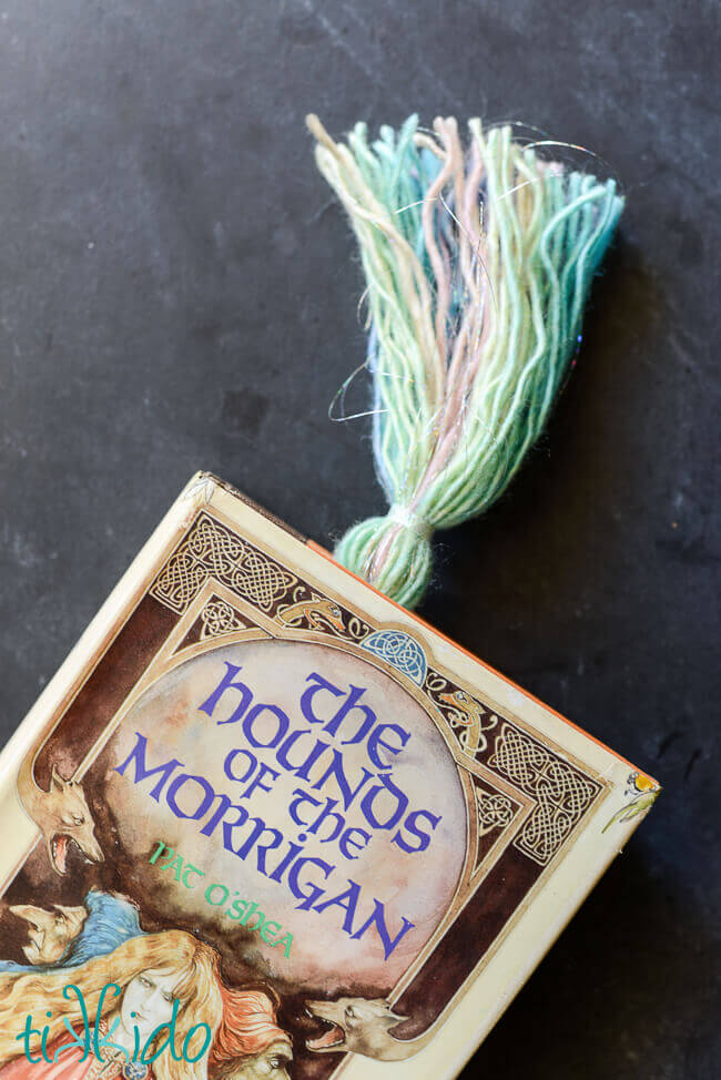 Yarn tassel tail of a unicorn bookmark sticking out of the top of The Hounds of the Morrigan book.