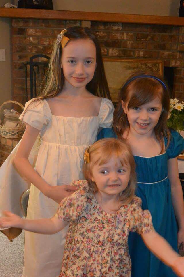 Three girls wearing empire waisted regency style dresses for the Jane Austen tea party birthday.
