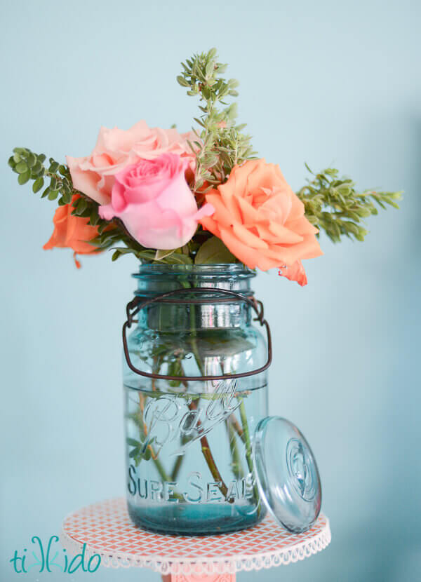Antique blue ball jar filled with pink and coral roses at the A is for Addalyn First Birthday Brunch