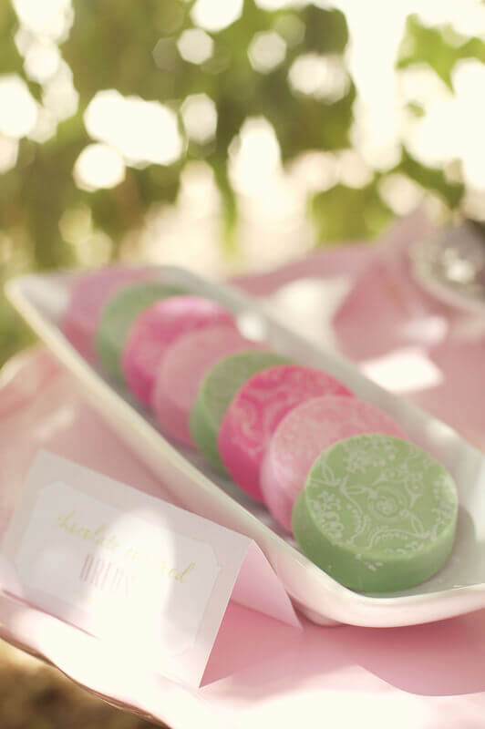 white tray holding pink and green Fancy Chocolate Covered Oreos covered in a delicate white damask pattern.