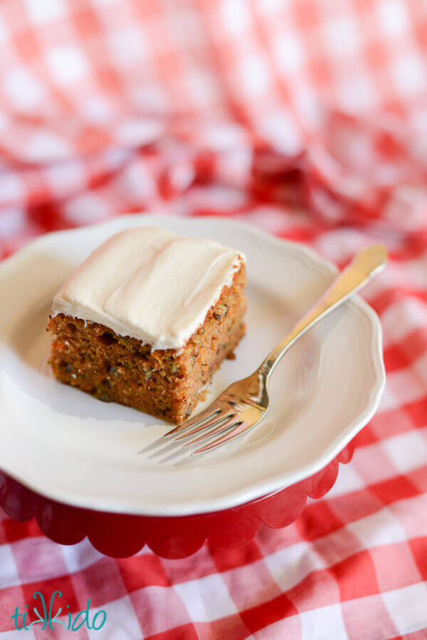Square slice of carrot cake topped with cream cheese frosting.